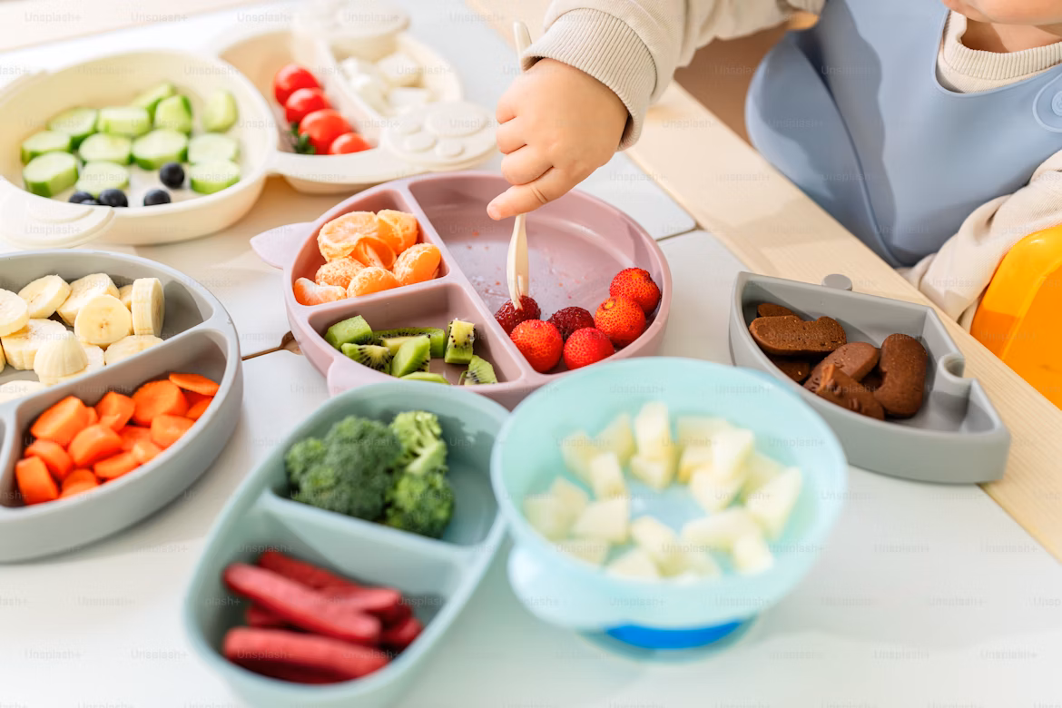 Parent feeding baby first foods at home