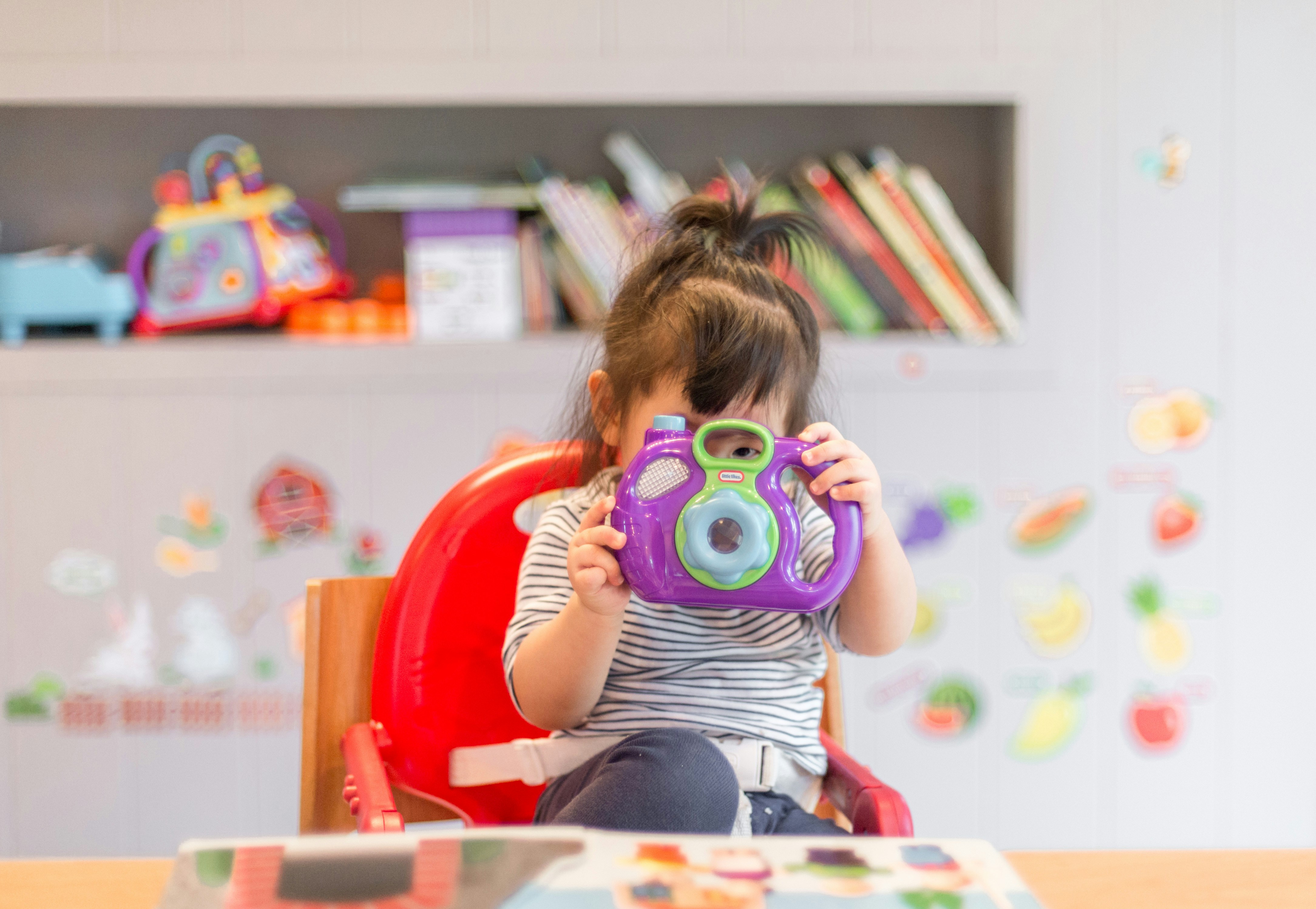 Toddler eating healthy meal in high chair